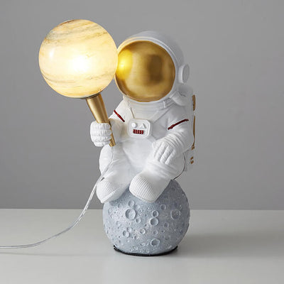Kreativer Cartoon-Astronaut, der Jupiter 1-Licht-Harz-Tischlampen hält 